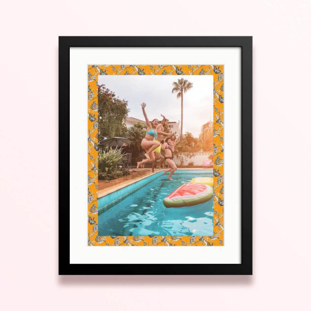 Framed and mounted photo print with vibrant orange border featuring a group of people jumping into a pool with one photo.