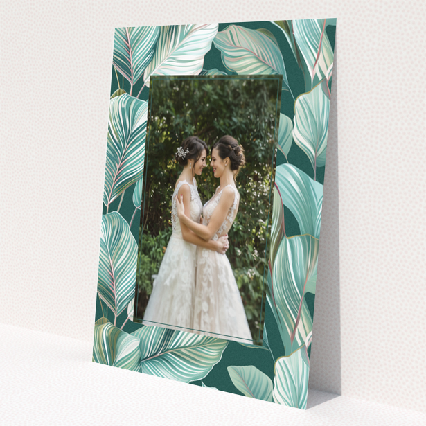 Wedding invitation design with tropical leaf pattern and one photo of a couple.