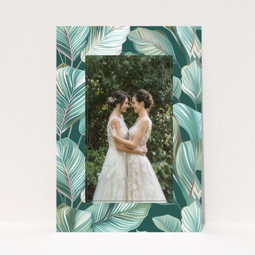 Wedding invitation design with tropical leaf pattern and one photo of a couple.