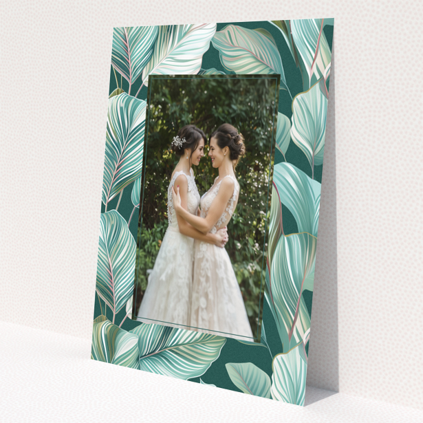 Wedding invitation design with tropical leaf pattern and one photo of a couple.