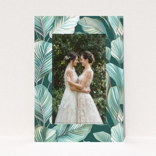 Wedding invitation design with tropical leaf pattern and one photo of a couple.
