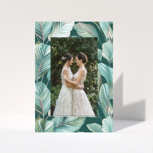 Wedding invitation design with tropical leaf pattern and one photo of a couple.