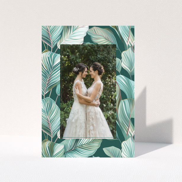 Wedding invitation design with tropical leaf pattern and one photo of a couple.