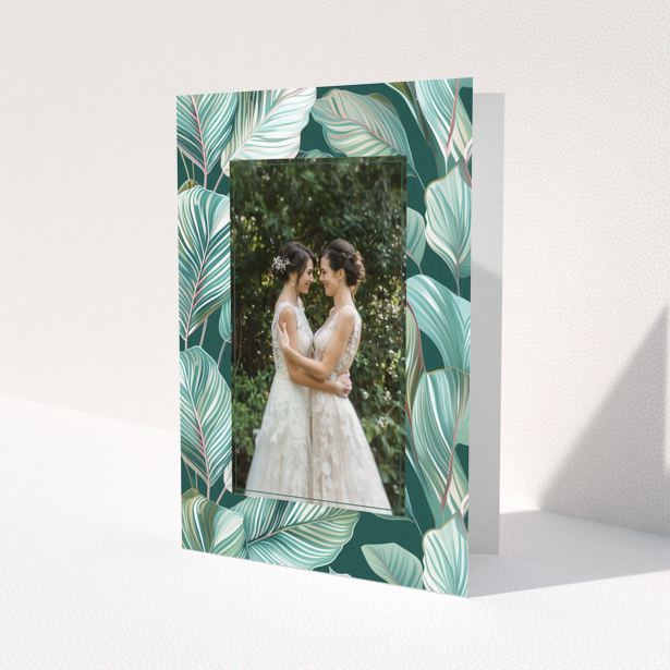 Wedding invitation design with tropical leaf pattern and one photo of a couple.