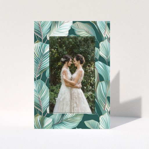 Wedding invitation design with tropical leaf pattern and one photo of a couple.