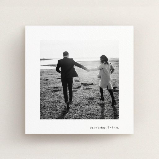 A wedding invite card named "Knot Tying". It is a square (148mm x 148mm) invite in a square orientation. It is a photographic wedding invite card with room for 1 photo. "Knot Tying" is available as a flat invite, with mainly white colouring.