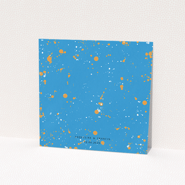 A wedding invite card design titled "Orange Splatters". It is a square (148mm x 148mm) invite in a square orientation. "Orange Splatters" is available as a flat invite, with tones of light blue and orange.