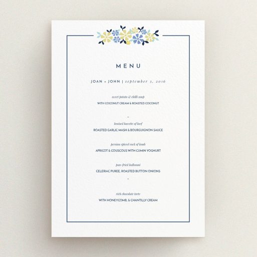 Wedding Menu Card Design - "In a border of flowers" A wedding menu card design titled "In a border of flowers". It is an A5 menu in a portrait orientation. "In a border of flowers" is available as a flat menu, with tones of white and blue.