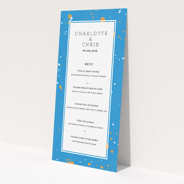 A wedding menu card design titled "Orange Splatters". It is a tall (DL) menu in a portrait orientation. "Orange Splatters" is available as a flat menu, with tones of light blue and orange.