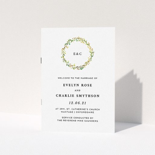 A wedding order of service called "Classic Monogrammed Wreath". It is an A5 booklet in a portrait orientation. "Classic Monogrammed Wreath" is available as a folded booklet booklet, with tones of white and green.