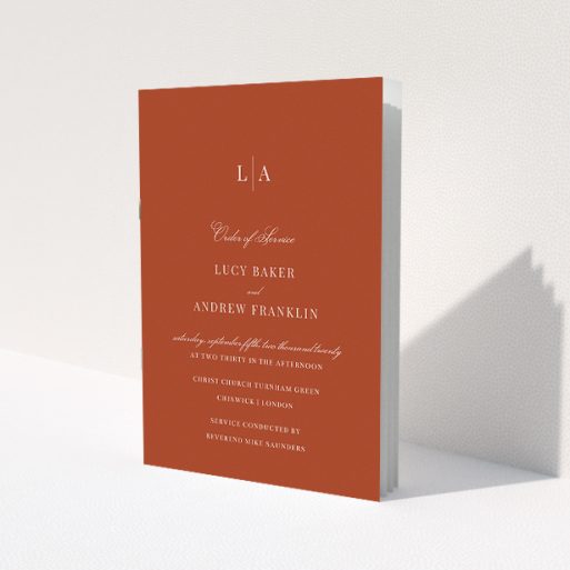 A wedding order of service named 'Dark Ochre Monogrammed'. It is an A5 booklet in a portrait orientation. 'Dark Ochre Monogrammed' is available as a folded booklet booklet, with mainly dark orange colouring.