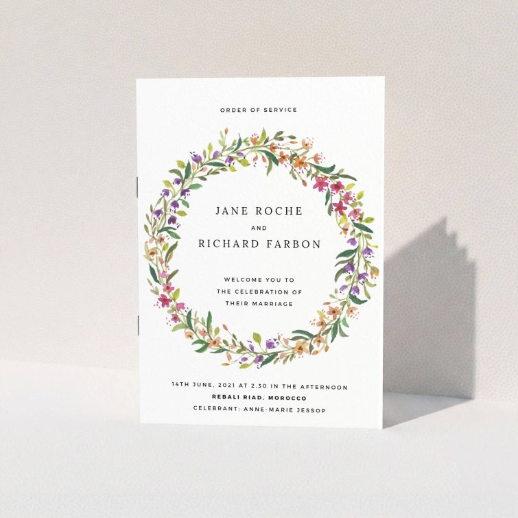 A wedding order of service named "Spring Wildflower". It is an A5 booklet in a portrait orientation. "Spring Wildflower" is available as a folded booklet booklet, with tones of light green and orange.