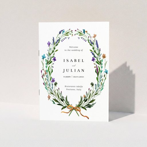 A wedding order of service named "Spring Wildflower Wreath". It is an A5 booklet in a portrait orientation. "Spring Wildflower Wreath" is available as a folded booklet booklet, with tones of green and purple.