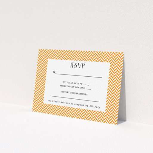 A wedding response card called 'Orange Houndstooth'. It is an A7 card in a landscape orientation. 'Orange Houndstooth' is available as a flat card, with tones of orange and white.