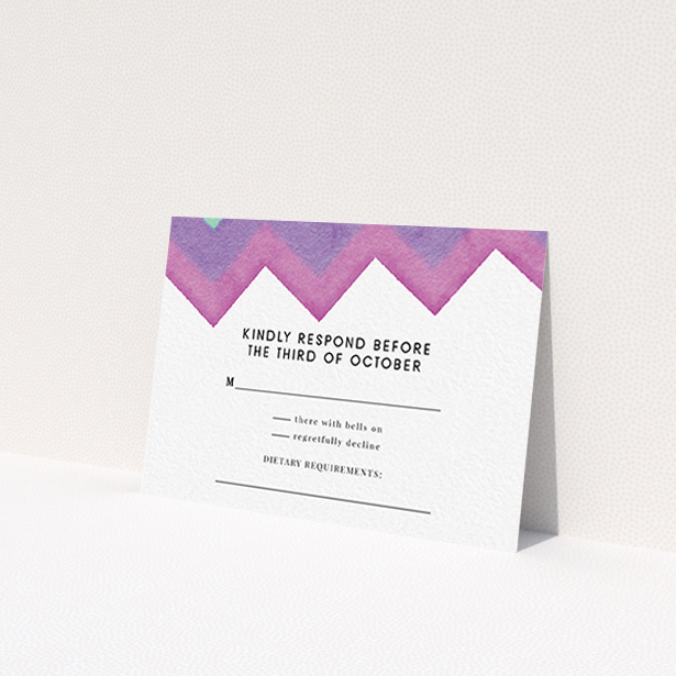 A wedding rsvp card design named "Vibrant Peaks". It is an A7 card in a landscape orientation. "Vibrant Peaks" is available as a flat card, with tones of white, dark pink and purple.