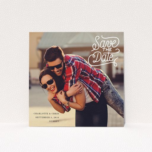 A wedding save the date card template titled "Curly Typography Photo". It is a square (148mm x 148mm) card in a square orientation. It is a photographic wedding save the date card with room for 1 photo. "Curly Typography Photo" is available as a flat card, with mainly white colouring.