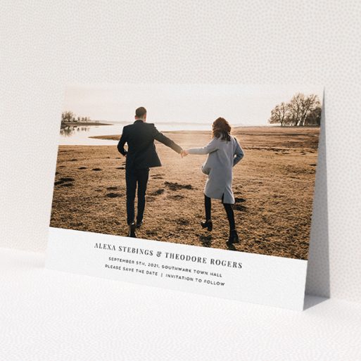 A wedding save the date card design titled 'Duke of York Square'. It is an A5 card in a landscape orientation. It is a photographic wedding save the date card with room for 1 photo. 'Duke of York Square' is available as a flat card, with mainly white colouring.