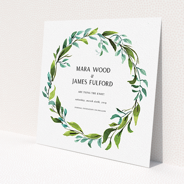A wedding save the date card design named "Greek Wreath". It is a square (148mm x 148mm) card in a square orientation. "Greek Wreath" is available as a flat card, with tones of blue and green.