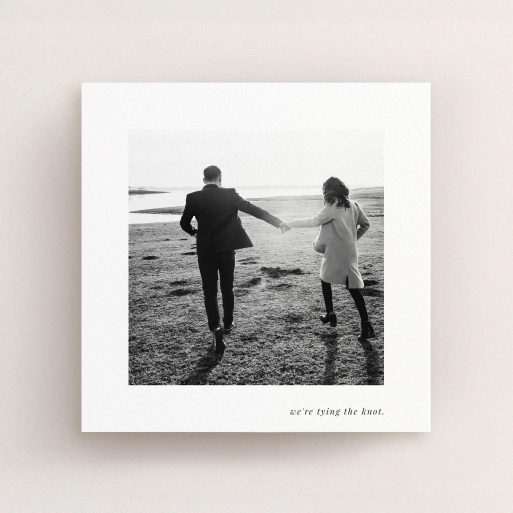 A wedding save the date card template titled "Knot Tying". It is a square (148mm x 148mm) card in a square orientation. It is a photographic wedding save the date card with room for 1 photo. "Knot Tying" is available as a flat card, with mainly white colouring.