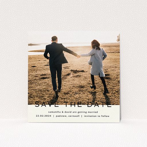 A wedding save the date card design called "Simple Saving". It is a square (148mm x 148mm) card in a square orientation. It is a photographic wedding save the date card with room for 1 photo. "Simple Saving" is available as a flat card, with tones of cream and black.