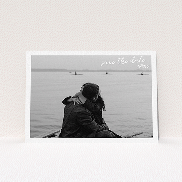 A wedding save the date card design called "Thick White Framed Photo". It is an A6 card in a landscape orientation. It is a photographic wedding save the date card with room for 1 photo. "Thick White Framed Photo" is available as a flat card, with mainly white colouring.