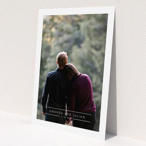 A wedding save the date card called 'Tramlines'. It is an A5 card in a portrait orientation. It is a photographic wedding save the date card with room for 1 photo. 'Tramlines' is available as a flat card, with mainly white colouring.
