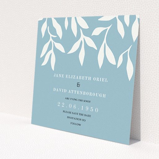 A wedding save the date card named 'Winter bloom'. It is a square (148mm x 148mm) card in a square orientation. 'Winter bloom' is available as a flat card, with tones of blue and white.