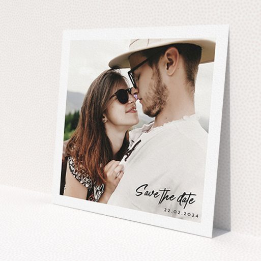 A wedding save the date called 'Script Corner'. It is a square (148mm x 148mm) save the date in a square orientation. It is a photographic wedding save the date with room for 1 photo. 'Script Corner' is available as a flat save the date, with mainly white colouring.