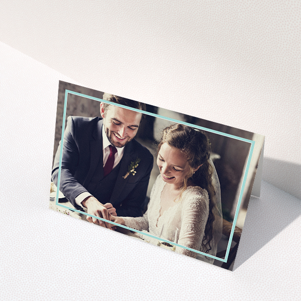 A wedding thank you card called "Blue White Photo Frame". It is an A5 card in a landscape orientation. It is a photographic wedding thank you card with room for 1 photo. "Blue White Photo Frame" is available as a folded card, with mainly blue colouring.