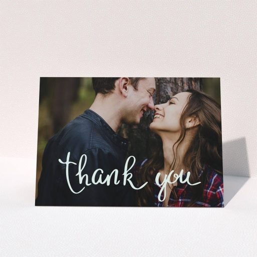 A wedding thank you card design named "Curly thank you". It is an A5 card in a landscape orientation. It is a photographic wedding thank you card with room for 1 photo. "Curly thank you" is available as a folded card, with mainly white colouring.