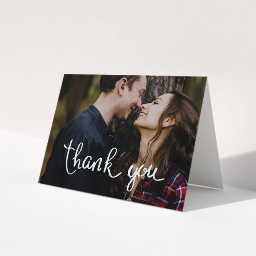 A wedding thank you card design named 'Curly thank you'. It is an A5 card in a landscape orientation. It is a photographic wedding thank you card with room for 1 photo. 'Curly thank you' is available as a folded card, with mainly white colouring.