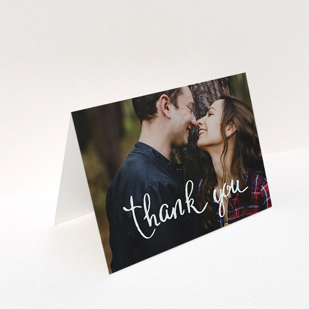 A wedding thank you card design named "Curly thank you". It is an A5 card in a landscape orientation. It is a photographic wedding thank you card with room for 1 photo. "Curly thank you" is available as a folded card, with mainly white colouring.