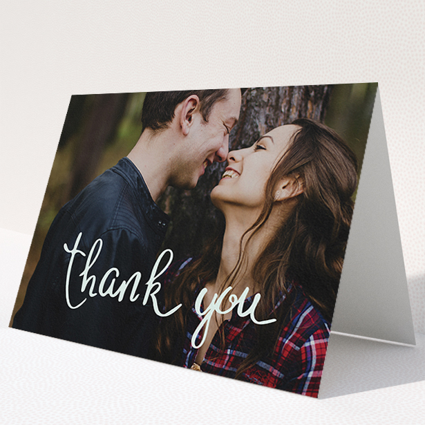 A wedding thank you card design named "Curly thank you". It is an A5 card in a landscape orientation. It is a photographic wedding thank you card with room for 1 photo. "Curly thank you" is available as a folded card, with mainly white colouring.