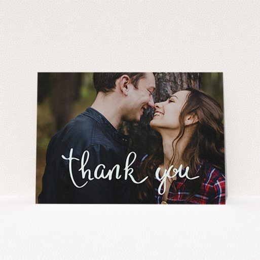 A wedding thank you card design titled "Curly thank you". It is an A6 card in a landscape orientation. It is a photographic wedding thank you card with room for 1 photo. "Curly thank you" is available as a flat card, with mainly white colouring.