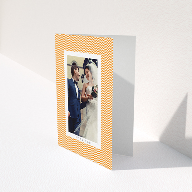 A wedding thank you card design called "Orange Houndstooth". It is an A6 card in a portrait orientation. It is a photographic wedding thank you card with room for 1 photo. "Orange Houndstooth" is available as a folded card, with tones of orange and white.