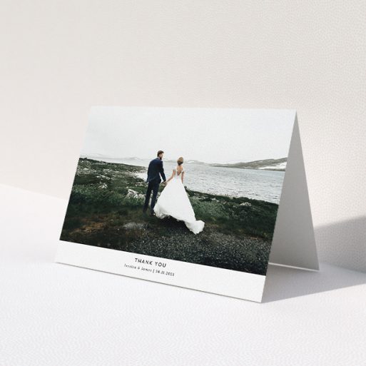 A wedding thank you card named 'Sans Serif'. It is an A5 card in a landscape orientation. It is a photographic wedding thank you card with room for 1 photo. 'Sans Serif' is available as a folded card, with mainly white colouring.