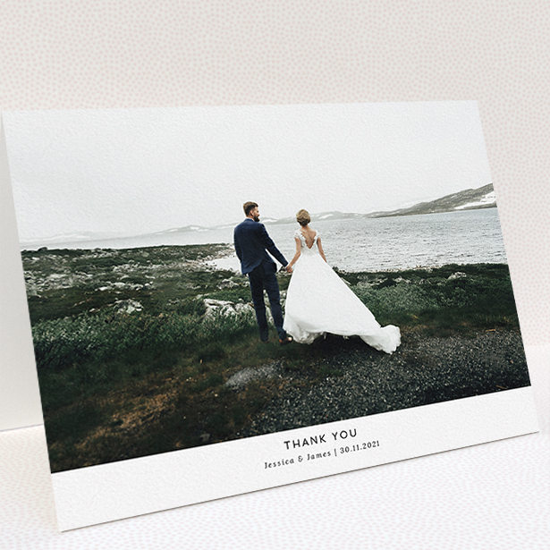A wedding thank you card named "Sans Serif". It is an A5 card in a landscape orientation. It is a photographic wedding thank you card with room for 1 photo. "Sans Serif" is available as a folded card, with mainly white colouring.