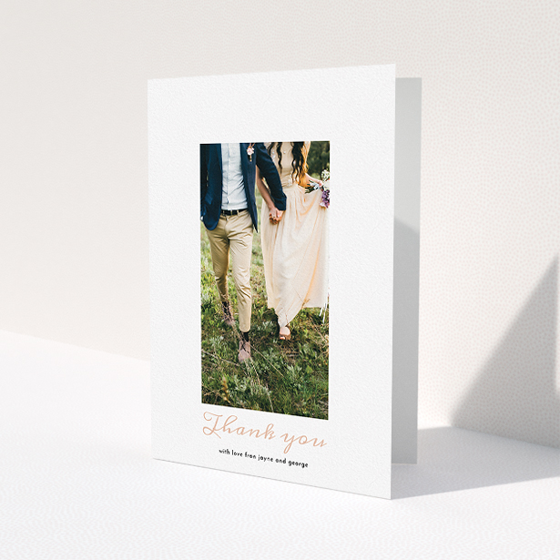 A wedding thank you card called "Small and Central". It is an A5 card in a portrait orientation. It is a photographic wedding thank you card with room for 1 photo. "Small and Central" is available as a folded card, with tones of white and pink.