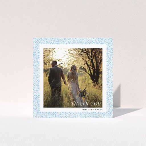 A wedding thank you card design called "Surrounded by flowers". It is a square (148mm x 148mm) card in a square orientation. It is a photographic wedding thank you card with room for 1 photo. "Surrounded by flowers" is available as a folded card, with tones of blue and white.
