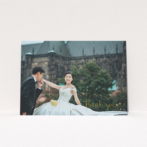 A wedding thank you card called "Thank you with a heart". It is an A6 card in a landscape orientation. It is a photographic wedding thank you card with room for 1 photo. "Thank you with a heart" is available as a flat card, with mainly gold colouring.