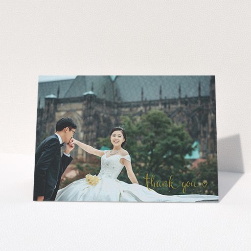 A wedding thank you card named "Thank you with a heart". It is an A6 card in a landscape orientation. It is a photographic wedding thank you card with room for 1 photo. "Thank you with a heart" is available as a folded card, with mainly gold colouring.