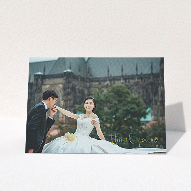 A wedding thank you card named "Thank you with a heart". It is an A6 card in a landscape orientation. It is a photographic wedding thank you card with room for 1 photo. "Thank you with a heart" is available as a folded card, with mainly gold colouring.