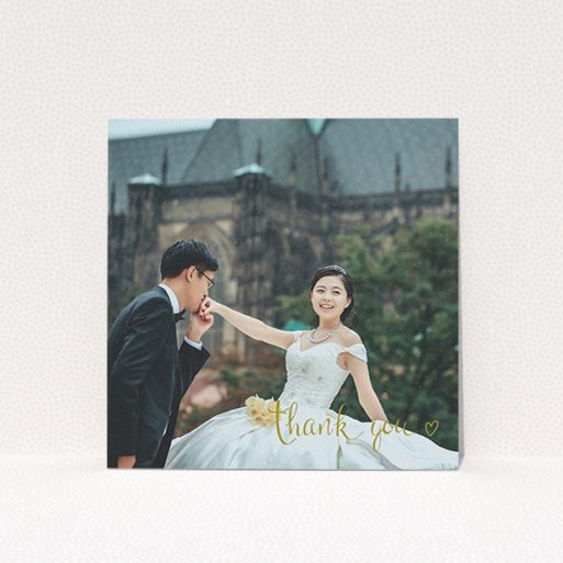 A wedding thank you card named "Thank you with a heart". It is a square (148mm x 148mm) card in a square orientation. It is a photographic wedding thank you card with room for 1 photo. "Thank you with a heart" is available as a flat card, with mainly gold colouring.