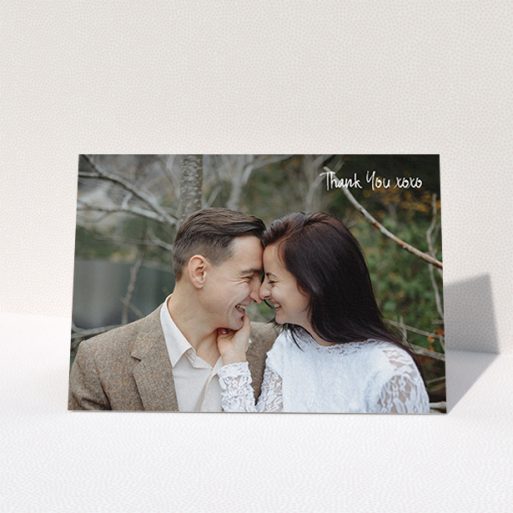 A wedding thank you card design named "Thank You XOXO". It is an A6 card in a landscape orientation. It is a photographic wedding thank you card with room for 1 photo. "Thank You XOXO" is available as a folded card, with mainly white colouring.