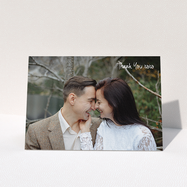 A wedding thank you card design named "Thank You XOXO". It is an A6 card in a landscape orientation. It is a photographic wedding thank you card with room for 1 photo. "Thank You XOXO" is available as a folded card, with mainly white colouring.