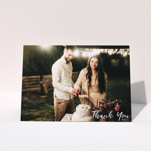 A wedding thank you card named "Thanks From The Corner". It is an A5 card in a landscape orientation. It is a photographic wedding thank you card with room for 1 photo. "Thanks From The Corner" is available as a folded card, with mainly white colouring.