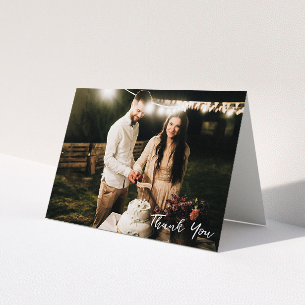 A wedding thank you card named "Thanks From The Corner". It is an A5 card in a landscape orientation. It is a photographic wedding thank you card with room for 1 photo. "Thanks From The Corner" is available as a folded card, with mainly white colouring.