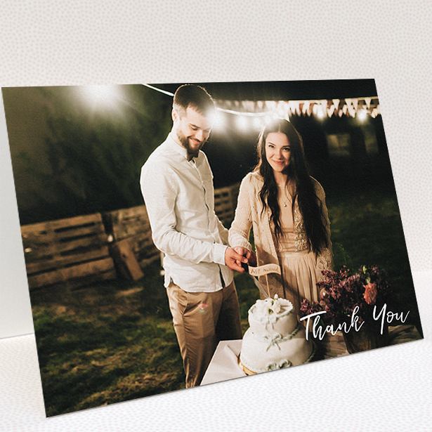 A wedding thank you card named "Thanks From The Corner". It is an A5 card in a landscape orientation. It is a photographic wedding thank you card with room for 1 photo. "Thanks From The Corner" is available as a folded card, with mainly white colouring.