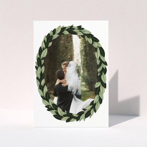 A wedding thank you card design titled "Thick Wreath Frame". It is an A5 card in a portrait orientation. It is a photographic wedding thank you card with room for 1 photo. "Thick Wreath Frame" is available as a folded card, with tones of light green and dark green.