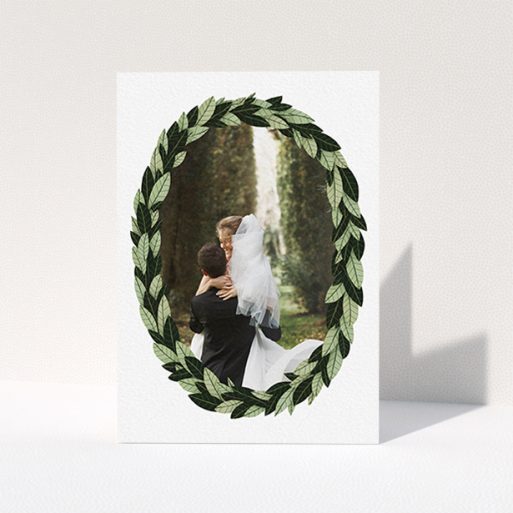 A wedding thank you card named "Thick Wreath Frame". It is an A6 card in a portrait orientation. It is a photographic wedding thank you card with room for 1 photo. "Thick Wreath Frame" is available as a folded card, with tones of light green and dark green.